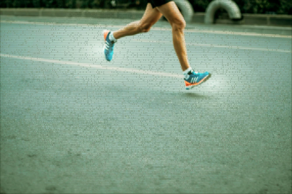A runner mid-stride on tarmac, both feet off the ground