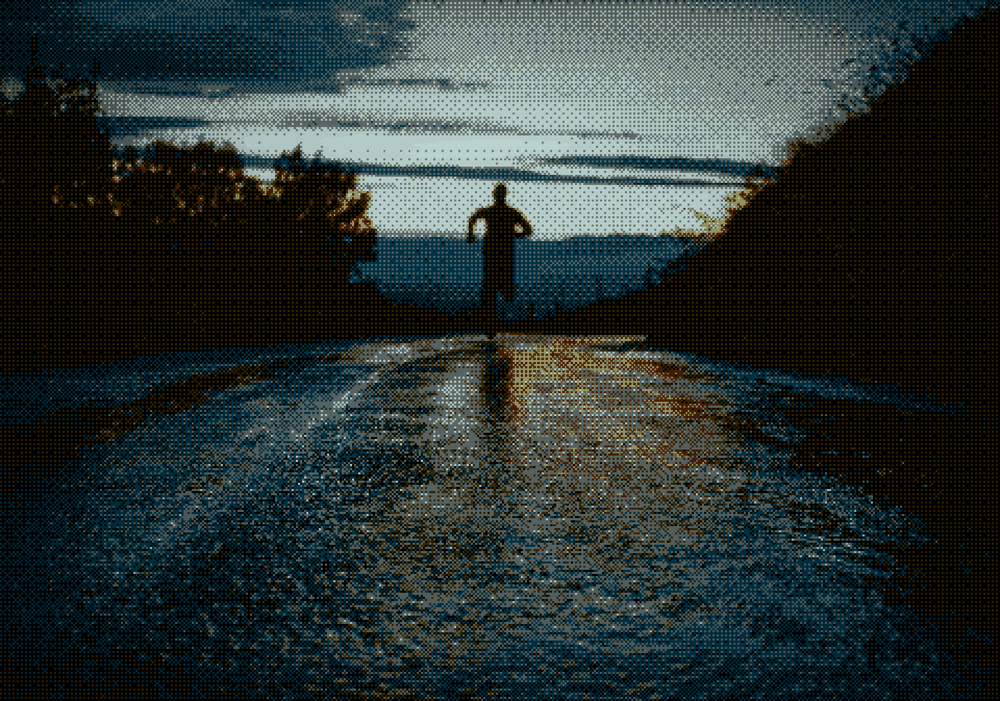 A runner on a wet road at dusk